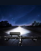 Multi-LED bike front light casting a wide beam along a road at night