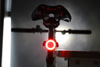 Rear bicycle view with a bright red halo light glowing beneath the saddle