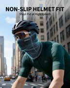 Cyclist wearing a blue-gray face covering under a helmet in an urban street